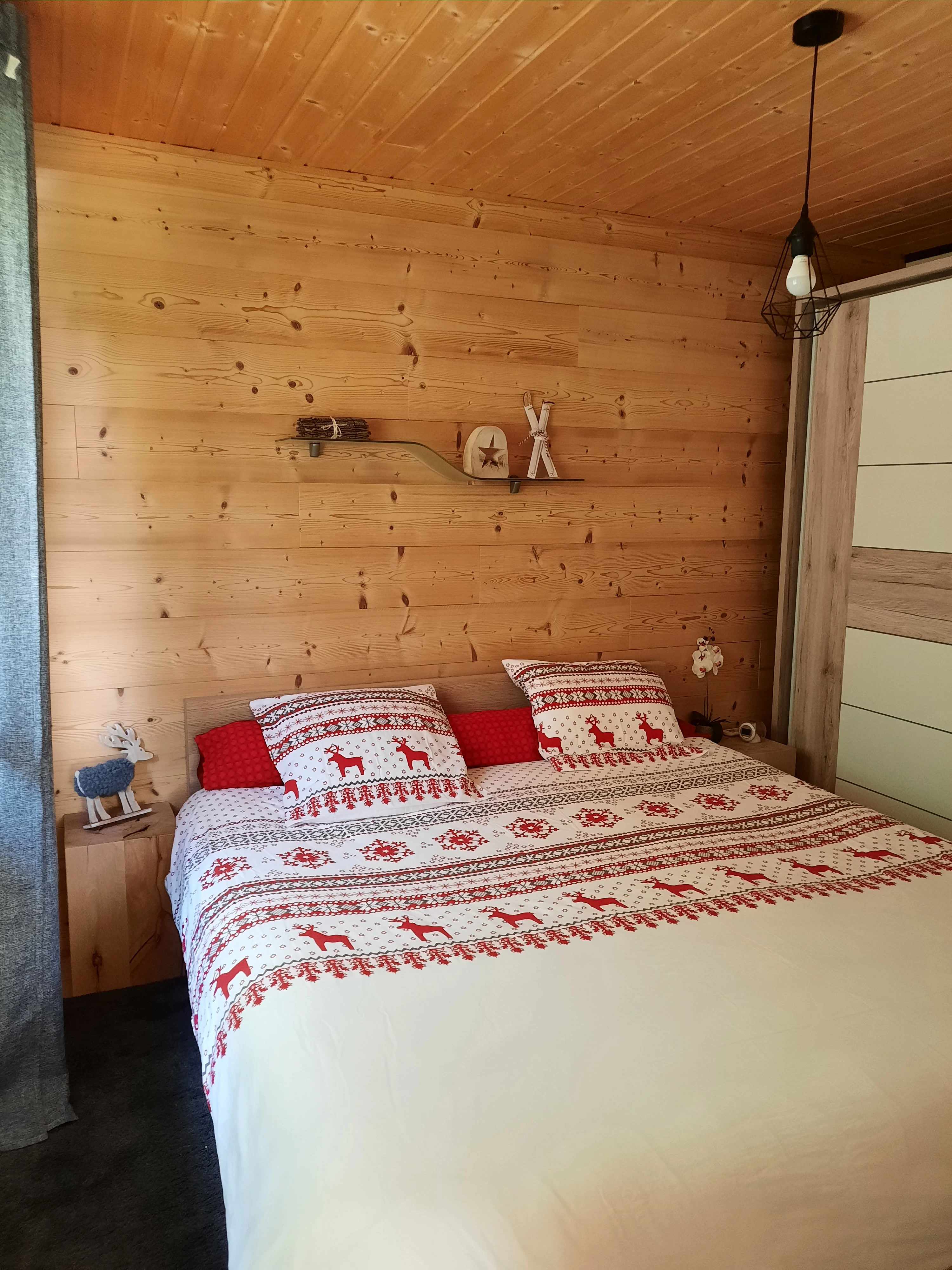 Chambre principale avec literie rouge et blanche