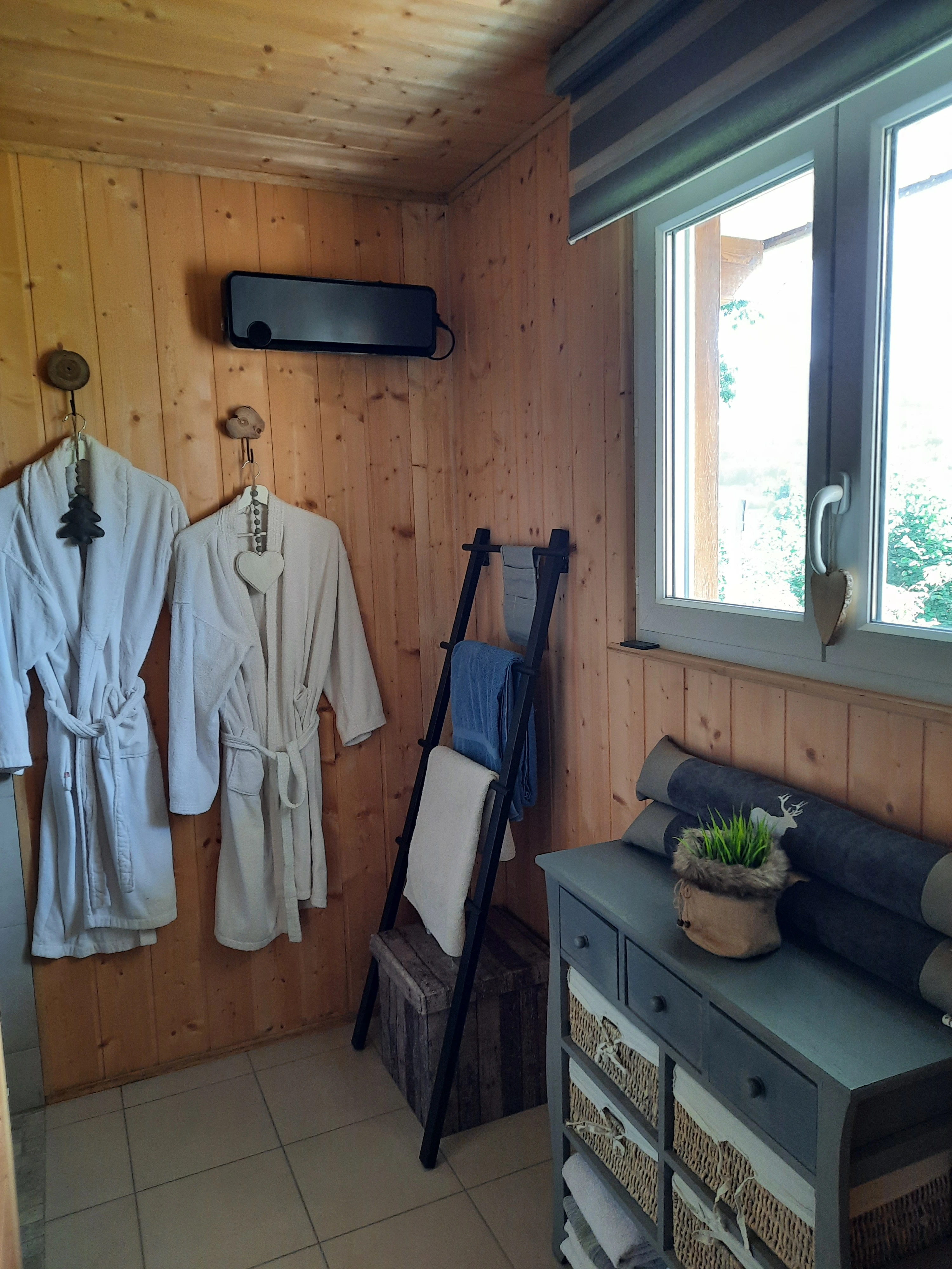 Salle d'eau du chalet avec douche à l'italienne et peignoirs