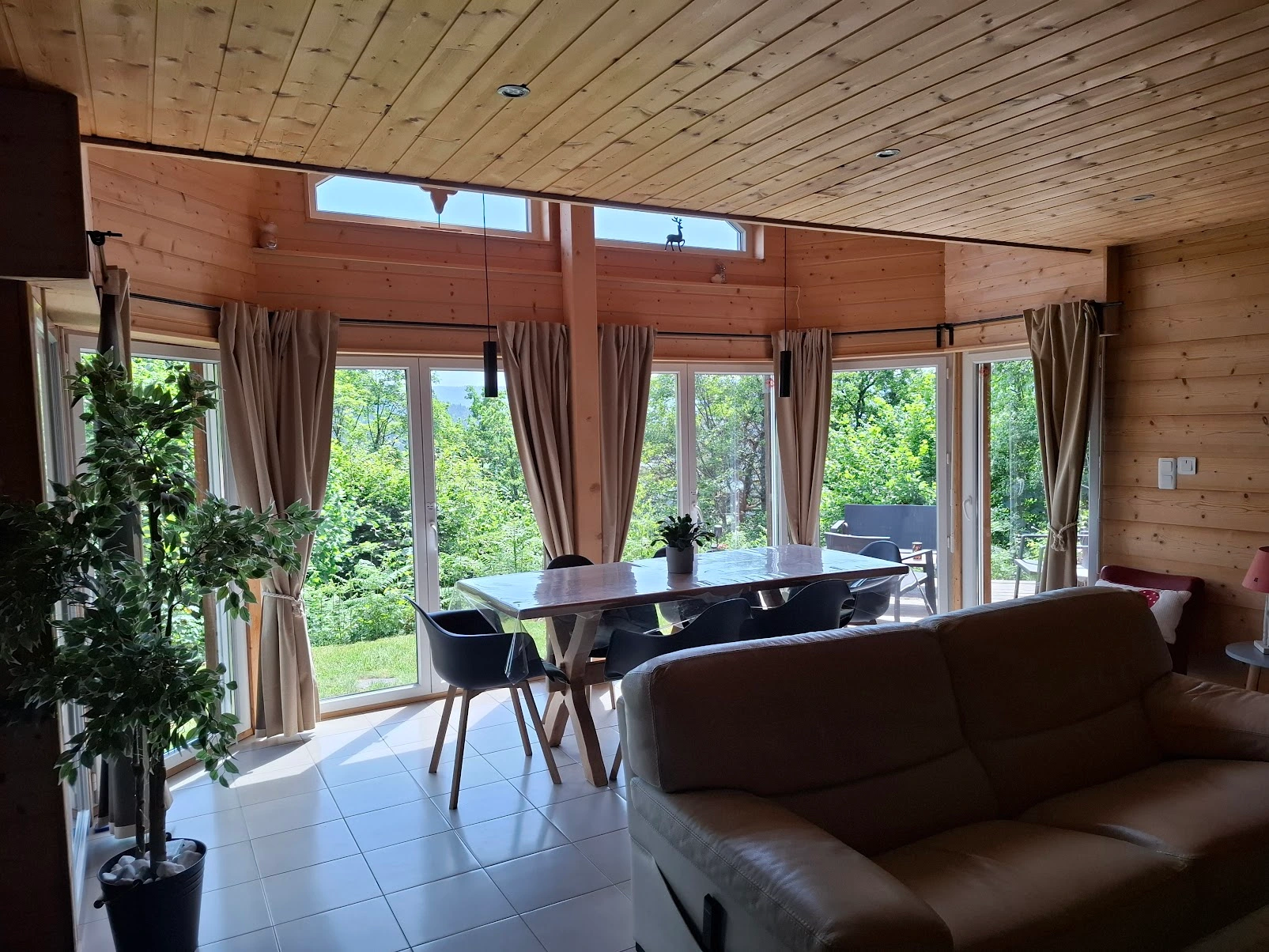 Salon et salle à manger du chalet ouverts sur les fenêtres
